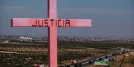 Auf einem rosafarbenen Kreuz steht „Justicia“