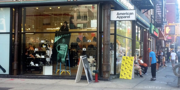 Ein Modegeschäft, daneben steht ein Schild mit Aufschrift "Sale" Ein Modegeschäft, daneben steht ein Schild mit Aufschrift "Sale"