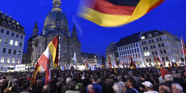 Pegida-Demonstranten mit Deutschlandflaggen vor der Frauenkirche in Dresden. Pegida-Demonstranten mit Deutschlandflaggen vor der Frauenkirche in Dresden.