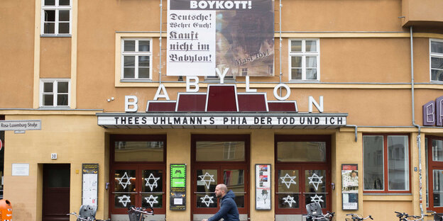 Eine Hausfassade, an der ein Plakat hängt, im Fenster sind Davidsterne zu sehen Eine Hausfassade, an der ein Plakat hängt, im Fenster sind Davidsterne zu sehen