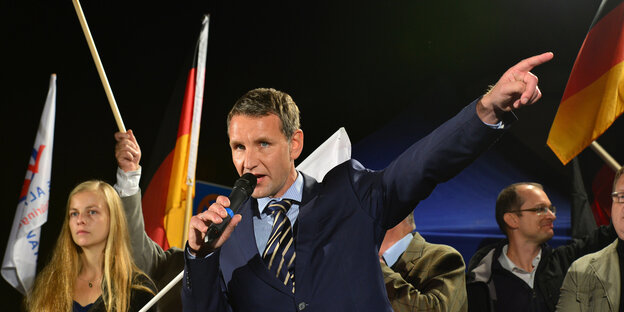 Höcke spricht in das Mikro vor Deutschlandflaggen Höcke spricht in das Mikro vor Deutschlandflaggen