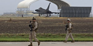 Soldaten laufen vorbei, ein „Eurofighter“ steht unter einem Dach