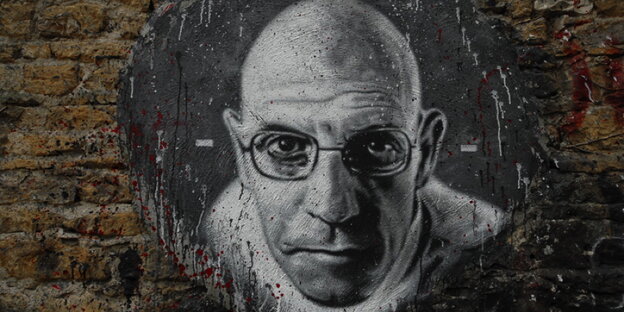 Ein schwarz-weißes Porträt von Foucault ist auf eine Mauer gesprüht Ein schwarz-weißes Porträt von Foucault ist auf eine Mauer gesprüht