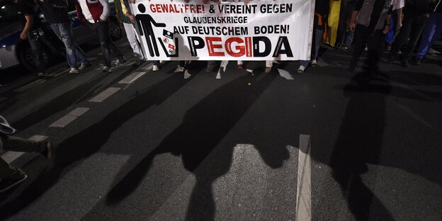 Menschen halten Pegida-Banner Menschen halten Pegida-Banner