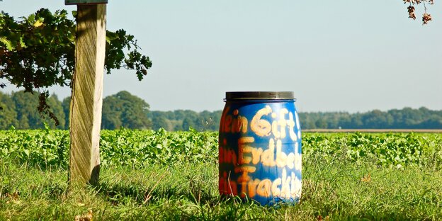 Fass mit gelbem Anti-Fracking Schriftzug auf einer Wiese