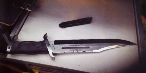 Ein großes Messer liegt auf einem Tisch Ein großes Messer liegt auf einem Tisch