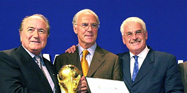 Blatter, Beckenbauer und Radmann freuen sich und halten den WM-Pokal Blatter, Beckenbauer und Radmann freuen sich und halten den WM-Pokal