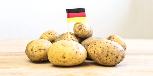 Eine Deutschlandfahne steckt in einem Berg Kartoffeln Eine Deutschlandfahne steckt in einem Berg Kartoffeln