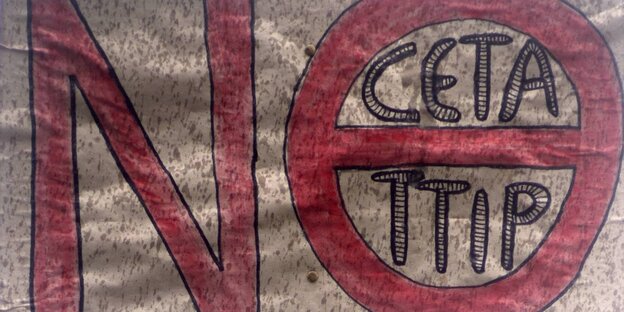 Ein Schild mit der Aufschrift "No", das O ist durchgestrichen und darin stehen die Abkürzungen TTIP und CETA Ein Schild mit der Aufschrift "No", das O ist durchgestrichen und darin stehen die Abkürzungen TTIP und CETA