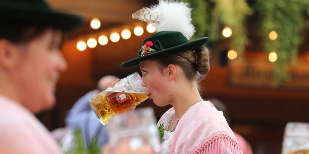 Eine Frau in Tracht trinkt Bier Eine Frau in Tracht trinkt Bier