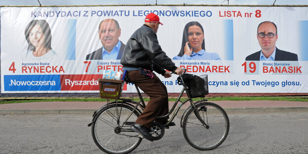 Ein Radfahrer fährt in Jablonna, in der Nähe von Warschau, an Wahlplakaten vorbei. Ein Radfahrer fährt in Jablonna, in der Nähe von Warschau, an Wahlplakaten vorbei.