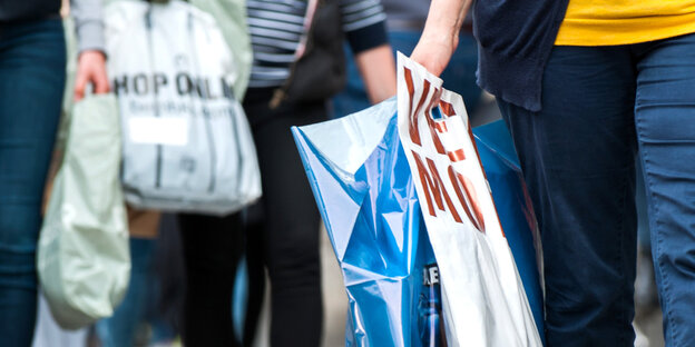 Kunden tragen Plastiktüten verschiedener Geschäfte. Kunden tragen Plastiktüten verschiedener Geschäfte.
