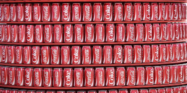 Coca-Cola-Dosen stehen in einem Regal. Coca-Cola-Dosen stehen in einem Regal.