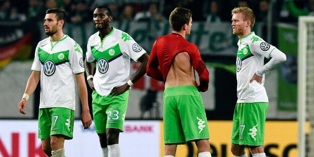 Bedröppelt reinschauende Spieler des VfL Wolfsburg.