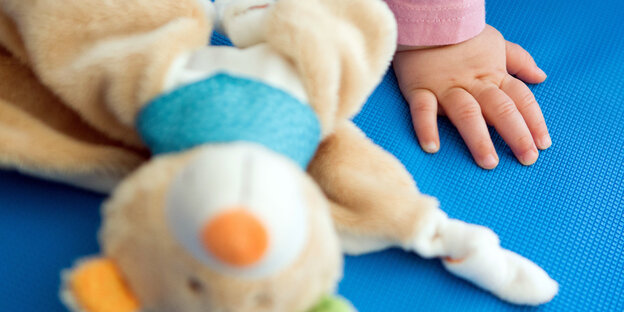 Kinderhand und Spielzeug Kinderhand und Spielzeug
