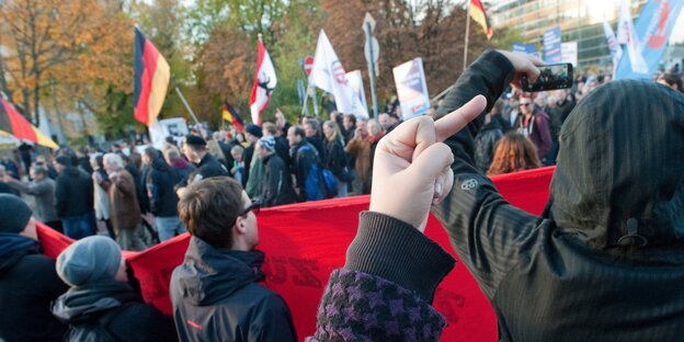 Demonstranten zeigen den Mittelfinger Demonstranten zeigen den Mittelfinger