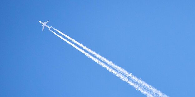 Flugzeug mit Kondensstreifen vor blauem Himmel. Flugzeug mit Kondensstreifen vor blauem Himmel.