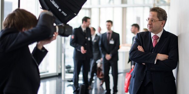 Ein Fotograf visiert mit seiner Kamera einen Mann im Anzug an, es ist Verfassungsschutzpräsident Hans-Georg Maaßen Ein Fotograf visiert mit seiner Kamera einen Mann im Anzug an, es ist Verfassungsschutzpräsident Hans-Georg Maaßen