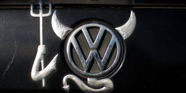 Das VW-Symbol mit Teufelsinsignien: Hörner, Schwanz und Dreizack Das VW-Symbol mit Teufelsinsignien: Hörner, Schwanz und Dreizack