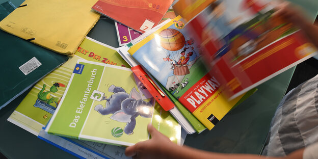 Schulmaterialien in Kinderhänden. Schulmaterialien in Kinderhänden.