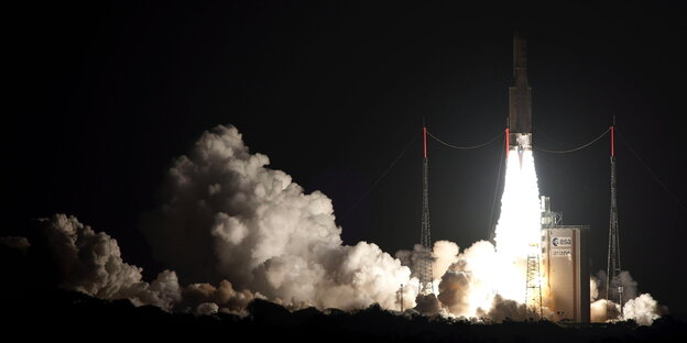 Eine Raketenstart erhellt die Nacht mit einer Wolke aus Feuer und Rauch Eine Raketenstart erhellt die Nacht mit einer Wolke aus Feuer und Rauch