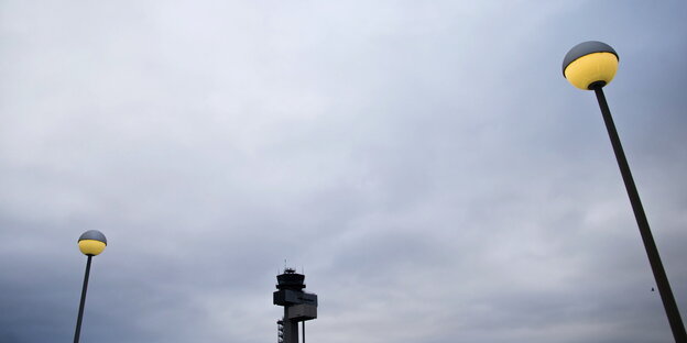 Zwischen zwei Laternen ist der Tower des Düsseldorfer Flughafens zu sehen Zwischen zwei Laternen ist der Tower des Düsseldorfer Flughafens zu sehen