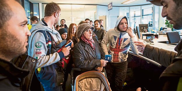 Am Schalter, der Fahrkarten nach Schweden verkauft, drängen sich verzweifelte Menschen Am Schalter, der Fahrkarten nach Schweden verkauft, drängen sich verzweifelte Menschen