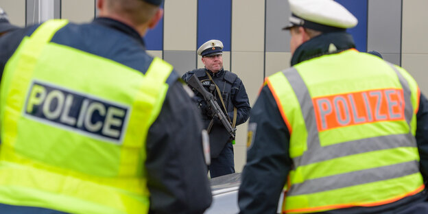 Deutsche und französische Polizisten am Sonntag an der Grenze bei Saarbrücken im Einsatz. Dazu ein dritter Polizist mit Maschinengewehr im Hintergrund Deutsche und französische Polizisten am Sonntag an der Grenze bei Saarbrücken im Einsatz. Dazu ein dritter Polizist mit Maschinengewehr im Hintergrund