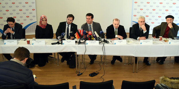 VertreterInnen islamischer Gruppen an einem langen Tisch. VertreterInnen islamischer Gruppen an einem langen Tisch.