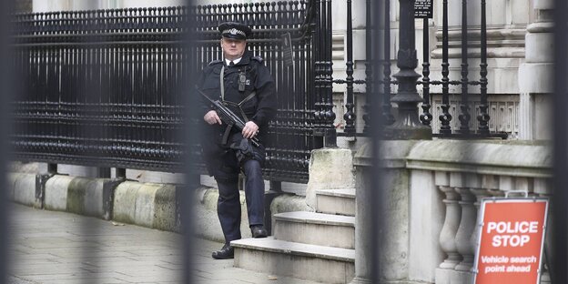 Ein bewaffneter Polizist steht vor einem Haus in der Downing treet Ein bewaffneter Polizist steht vor einem Haus in der Downing treet