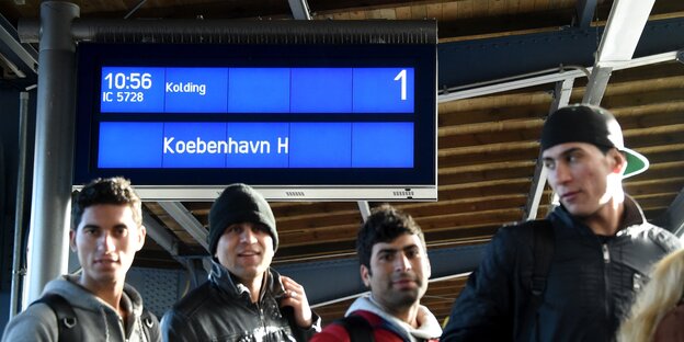 Flüchtlinge gehen ein Gleis auf dem Flensburger Bahnhof entlang. Flüchtlinge gehen ein Gleis auf dem Flensburger Bahnhof entlang.