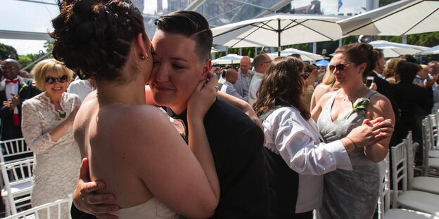 Zwei Frauen in Hochzeitskleidung umarmen sich Zwei Frauen in Hochzeitskleidung umarmen sich