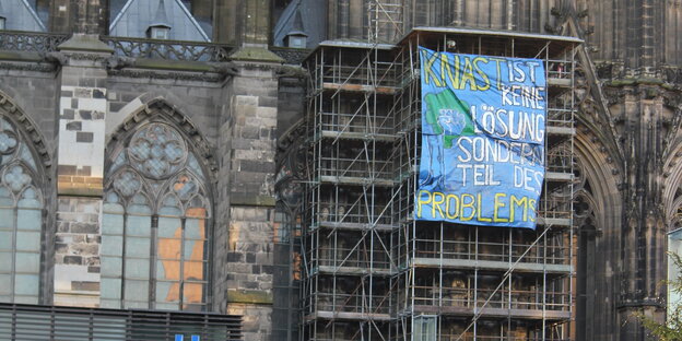 Ein Transparent hängt an einem Baugerüst am Kölner Dom. Ein Transparent hängt an einem Baugerüst am Kölner Dom.