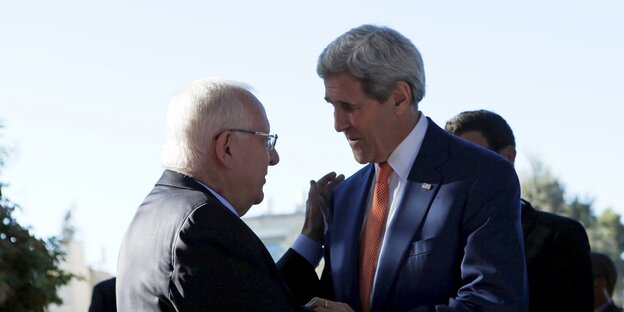 zwei Männer in Anzügen schütteln sich die Hände, es sind der israelische Staatspräsident Rivlin und US-Außenminister John Kerry zwei Männer in Anzügen schütteln sich die Hände, es sind der israelische Staatspräsident Rivlin und US-Außenminister John Kerry