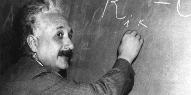 Albert Einstein schreibt mit Kreide Formeln an eine Tafel Albert Einstein schreibt mit Kreide Formeln an eine Tafel