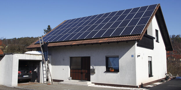 Ein Hausdacht ist mit einer Solaranlage bestückt Ein Hausdacht ist mit einer Solaranlage bestückt