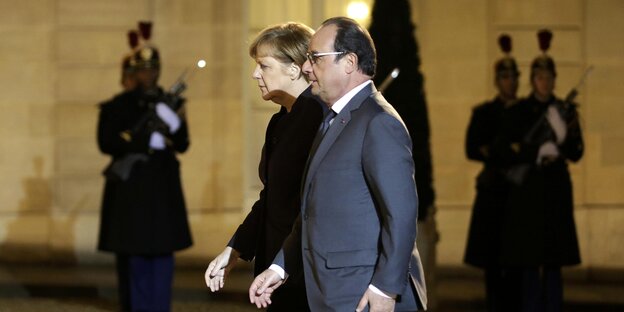 Merkel und Hollande gehen am Mittwochabend durch den Hof des Elysee Palasts in Paris Merkel und Hollande gehen am Mittwochabend durch den Hof des Elysee Palasts in Paris