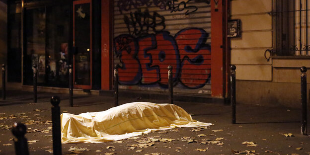 mit einem Tuch bedeckter Körper auf einer Straße - nach den Anschlägen von Paris am 13. November 2015 mit einem Tuch bedeckter Körper auf einer Straße - nach den Anschlägen von Paris am 13. November 2015