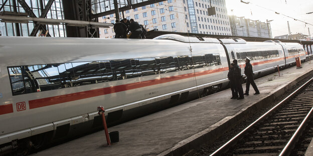 Ein Zug in einem Bahnhof, auf dem Dach Aktivisten und Polizisten Ein Zug in einem Bahnhof, auf dem Dach Aktivisten und Polizisten