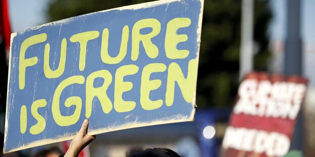 Ein blaues Schild mit in gelb geschriebenem Spruch: „Future is Green" Ein blaues Schild mit in gelb geschriebenem Spruch: „Future is Green"