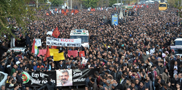 Hunderte Menschen auf einer Straße, auf einem Banner ist das Bild des erschossenen Anwalts Tahir Elçi zu sehen
