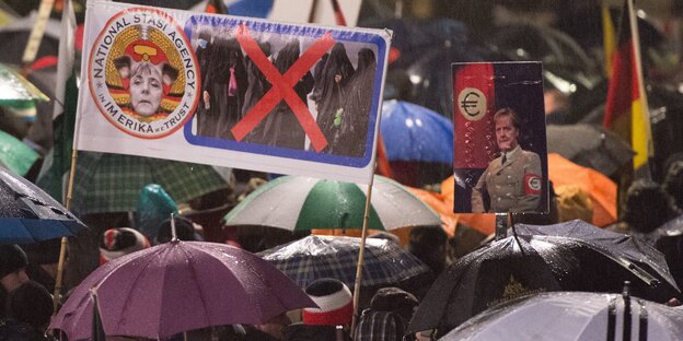 Regenschirme und Pegida-Plakate. Regenschirme und Pegida-Plakate.