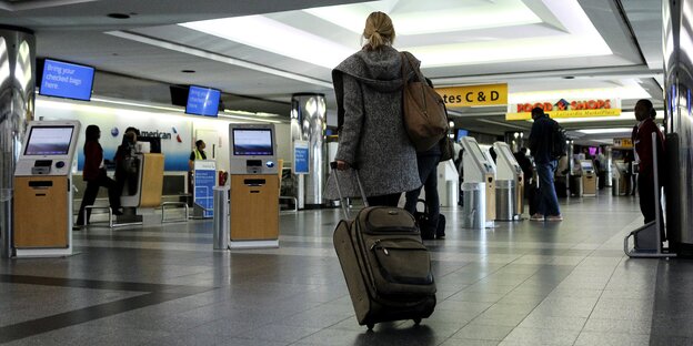 Frau mit Koffer am La Guardia-Flughafen Frau mit Koffer am La Guardia-Flughafen