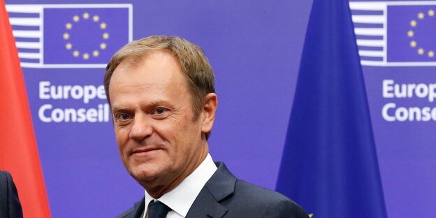 Ein Mann vor einer Europa-Fahne, es ist Kommissionspräsident Donald Tusk Ein Mann vor einer Europa-Fahne, es ist Kommissionspräsident Donald Tusk