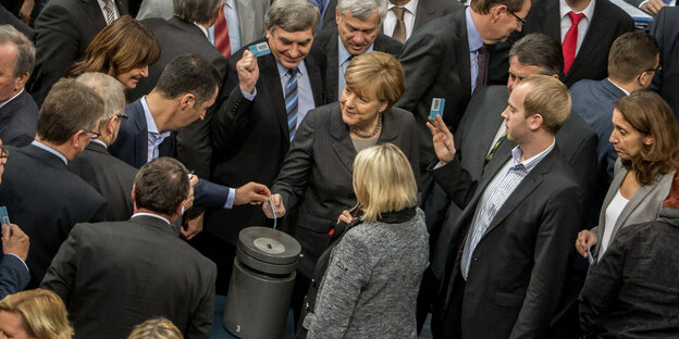 Bundestagsabgeordnete werfen Stimmkarten in eine Urne Bundestagsabgeordnete werfen Stimmkarten in eine Urne