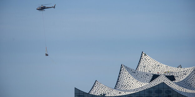 Ein Hubschrauber fliegt an der Elbphilharmonie vorbei Ein Hubschrauber fliegt an der Elbphilharmonie vorbei