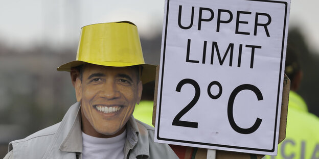 Ein Demonstrant trägt eine Obama Maske und ein Protestschild