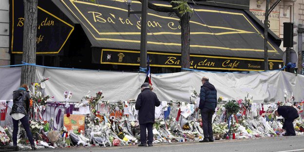 Menschen legen Blumen vor dem Bataclan Café ab Menschen legen Blumen vor dem Bataclan Café ab