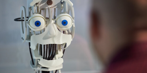 Ein Roboter ahmt die Grimasse eines Menschen nach Ein Roboter ahmt die Grimasse eines Menschen nach