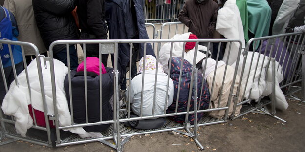 Flüchtlinge warten sitzend vor dem Lageso Flüchtlinge warten sitzend vor dem Lageso
